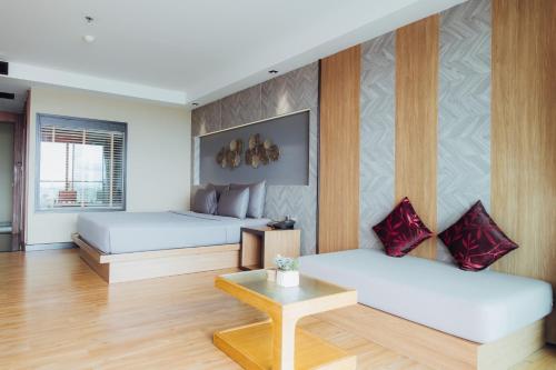 a room with two beds and a table at The Senses Resort & Pool Villas, PHUKET in Patong Beach