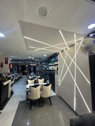 a restaurant with tables and chairs in a room at Hotel City Gold in Ajmer
