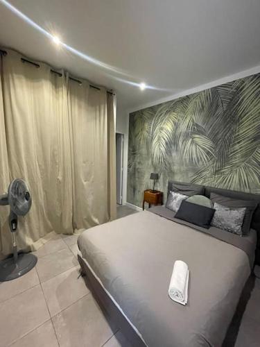 - une chambre avec un grand lit et une serviette dans l'établissement Jungle appart, à Nice