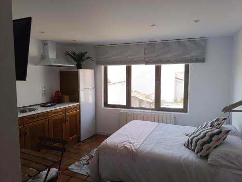 a bedroom with a bed and a kitchen with a window at Casa de la tía 2 in Simancas