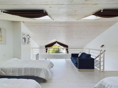 a bedroom with two beds and a blue chair at Maison pour 8 avec jardin a 600m de la plage in Le Sablais