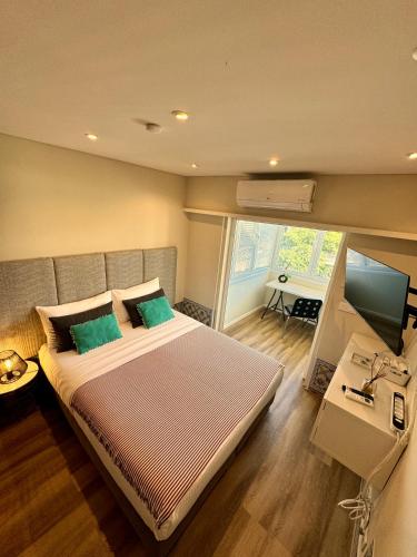 a bedroom with a large bed with two green pillows at Lx Art Flats | Flat Two in Lisbon