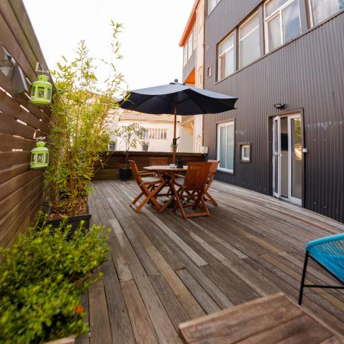 a wooden deck with a table and an umbrella at Bonjardim Terrace in Porto
