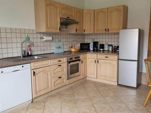 a kitchen with wooden cabinets and a white refrigerator at Ferienwohnung Fink in Gallin