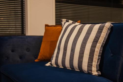a blue couch with pillows on top of it at Fitzgerald Focus - Your 1BR Urban Oasis in Christchurch