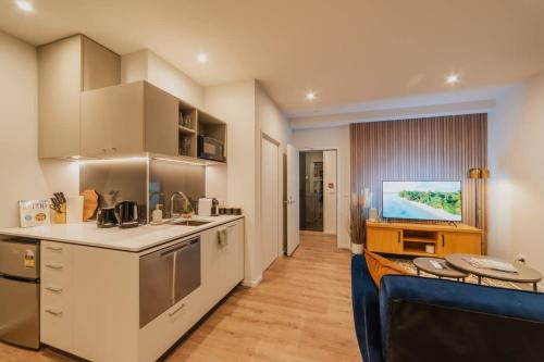 a kitchen with a couch and a tv in a room at Cashel Grandeur - Luxurious 4-Bedroom Home in Christchurch