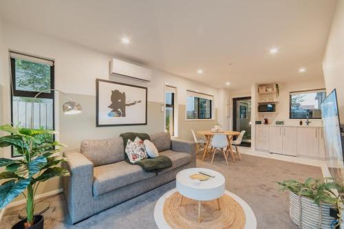 クライストチャーチにあるMisty Meadows Manor - Your Urban Oasisのソファとテーブルのあるリビングルーム