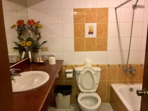 a bathroom with a sink and a toilet and a tub at Casa Cecilia Heritage Hotel in Taal