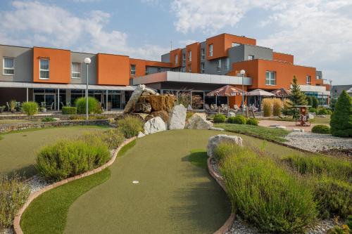 a golf course in front of a building at Hotel TENIS in Zvolen