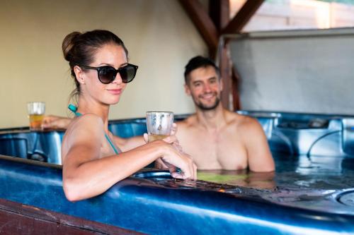 a man and a woman sitting in a bathtub at Fenyves Vendégház in Békésszentandrás
