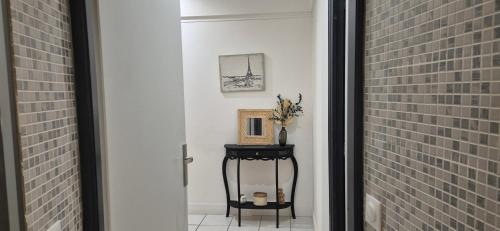 a hallway with a table with a picture on the wall at T3 spacieux lumineux jardin et proche du tram in Pont-de-la-Maye