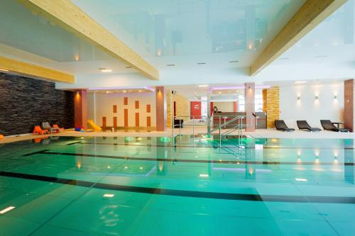 a large swimming pool in a hotel lobby at Hotel TENIS in Zvolen