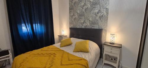 a bedroom with a bed with two yellow pillows at T3 spacieux lumineux jardin et proche du tram in Pont-de-la-Maye