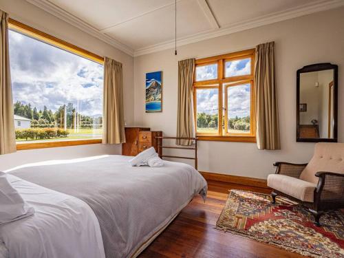 a bedroom with a bed and a chair and a window at MJ's Retreat Stunning Ski Season Special for 2024 in Ohakune