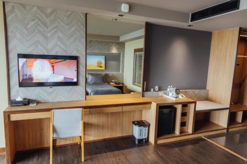 a room with a tv and a desk with a mirror at The Senses Resort & Pool Villas, PHUKET in Patong Beach