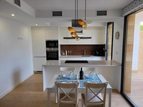 a kitchen with a table with wine glasses on it at Townhouse with jacuzzi, sauna, beach and barbeque in Villajoyosa