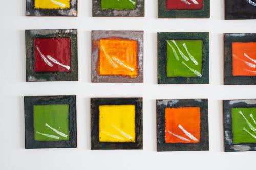 a row of colorful glass squares on a white wall at Hotel Villa Felice Relais in Amalfi