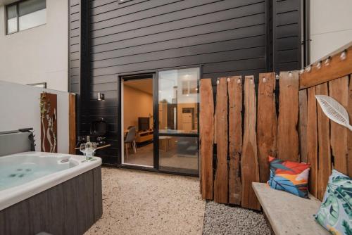 a bathroom with a tub and a wooden fence at Central City Paradise in Christchurch