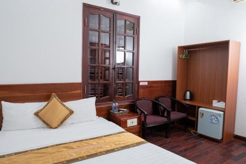 a bedroom with a bed and a desk and a chair at Khách Sạn Như Mai in Quang Tri