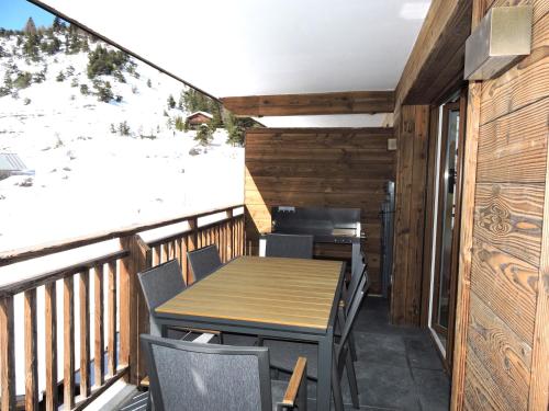d'une terrasse avec une table et des chaises sur un balcon. dans l'établissement La détente, vues, espaces le tout dans une décoration superbe, à Auron