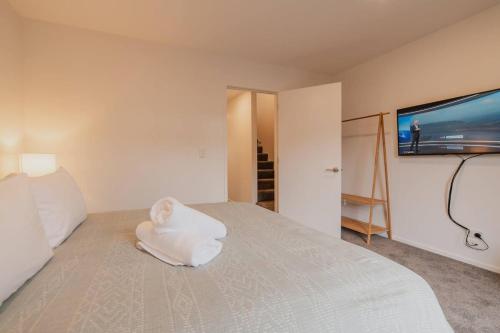 a bedroom with a bed with a baby toy on it at Downtown Bliss - 4-BR Retreat Amidst the Cityscape in Christchurch
