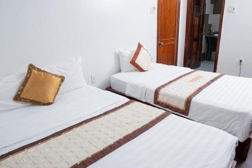 two beds sitting next to each other in a room at Khách Sạn Như Mai in Quang Tri