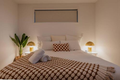a bedroom with a large white bed with two lamps at Addington Stadium Stay - Sleeps 6 in Christchurch