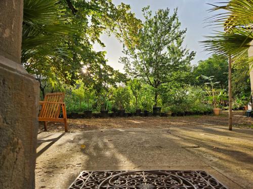 a wooden bench sitting on the side of a driveway at Chambre d'hôtes Les Berges de l'Aude - B&B - Proche Canal du midi & Carcassonne in Puicheric