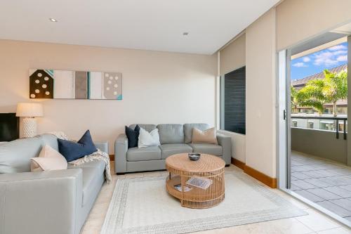 a living room with a couch and a table at 208 Santai - Spacious Family Apartment by uHoliday in Casuarina