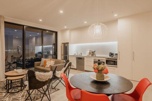 a kitchen and living room with a table and chairs at Tuam on Top Sleeps 5 in Christchurch