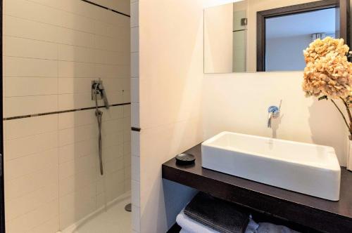 a white bathroom with a sink and a mirror at Gray D'Albion Cannes 2 BDR Apartment in Cannes
