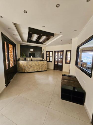 a large living room with a counter and a kitchen at Hotel L'Aiglon in Bcharré