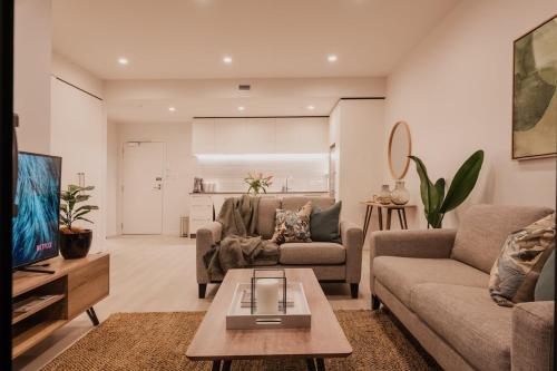 a living room with a couch and a table at Serene Spaces on Tuam - 2 Bedroom Apartment in Christchurch