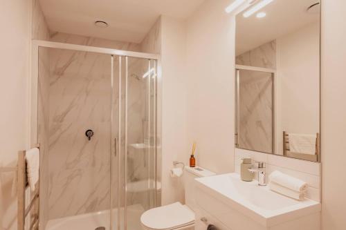 a bathroom with a shower and a toilet and a sink at Serene Spaces on Tuam - 2 Bedroom Apartment in Christchurch