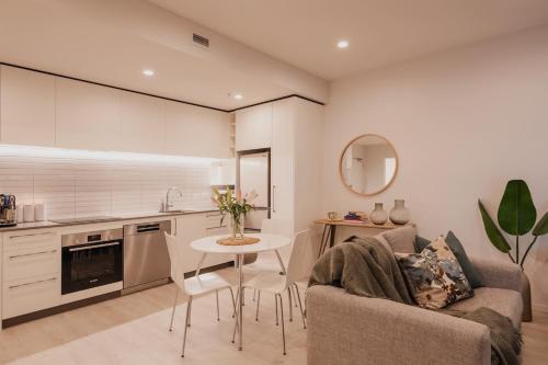 a kitchen and living room with a table and a couch at Serene Spaces on Tuam - 2 Bedroom Apartment in Christchurch