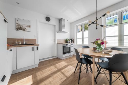 a kitchen and dining room with a table and chairs at Leneshus in Flensburg