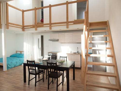 a dining room and kitchen with a loft bed at Apartment Brno Reissigova in Brno