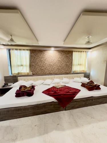 a bedroom with a large bed with red pillows on it at Hotel City Gold in Ajmer