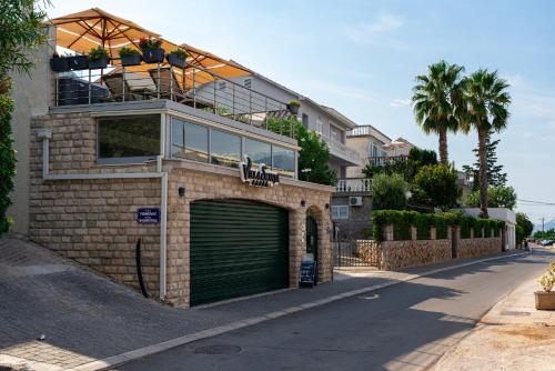 a house with a green garage door and a balcony at Villa Sonja Apartments in Krasici