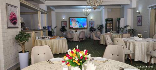 a banquet room with tables and chairs and a screen at BEK PLUS HOTEL in Takchilik