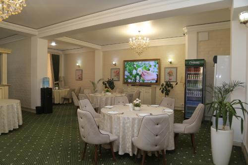 a banquet room with tables and chairs and a tv at BEK PLUS HOTEL in Takchilik