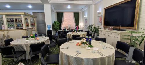 a dining room with tables and chairs and a large screen at BEK PLUS HOTEL in Takchilik