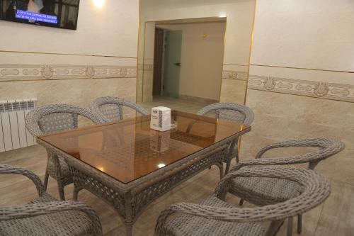 a dining room table with chairs and a box on it at BEK PLUS HOTEL in Takchilik