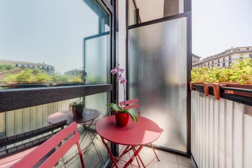 a balcony with two chairs and a table and a window at Hotel Milano Navigli in Milan