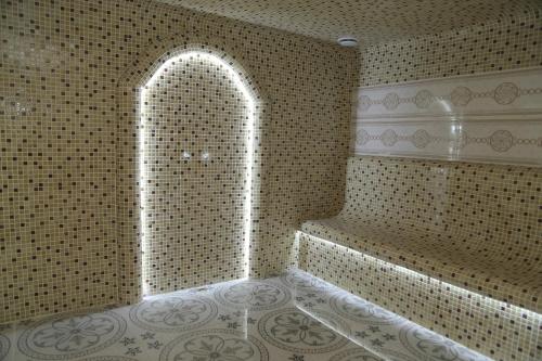 a bathroom with a walk in shower with a sink at BEK PLUS HOTEL in Takchilik
