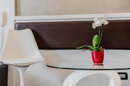a table with a vase with white flowers on it at Hotel Milano Navigli in Milan