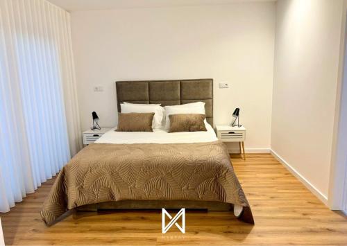 a bedroom with a large bed and two night stands at MyStay - Encosta da Barragem in Fafe