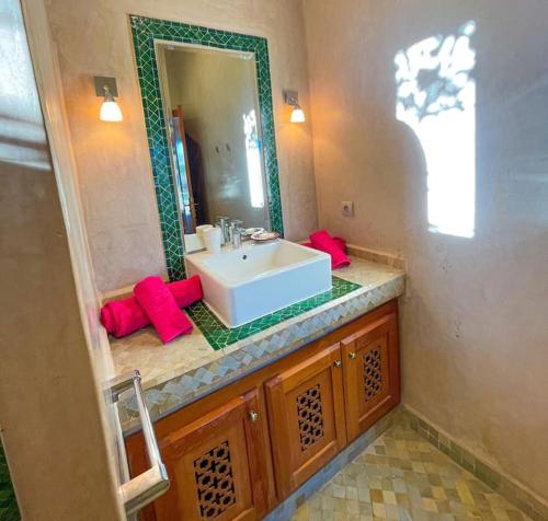 a bathroom with a white sink and a mirror at Villa Nooreben, à Marrakech in Marrakech