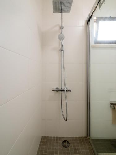 a shower with a shower head in a bathroom at Regatta - Beachfront and Sea Views in Ponta Delgada