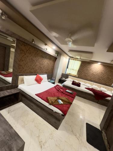 a hotel room with two beds and a mirror at Hotel City Gold in Ajmer